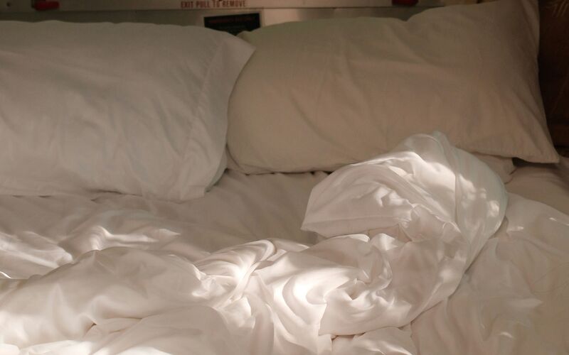 Bright white bedding with soft light through curtains