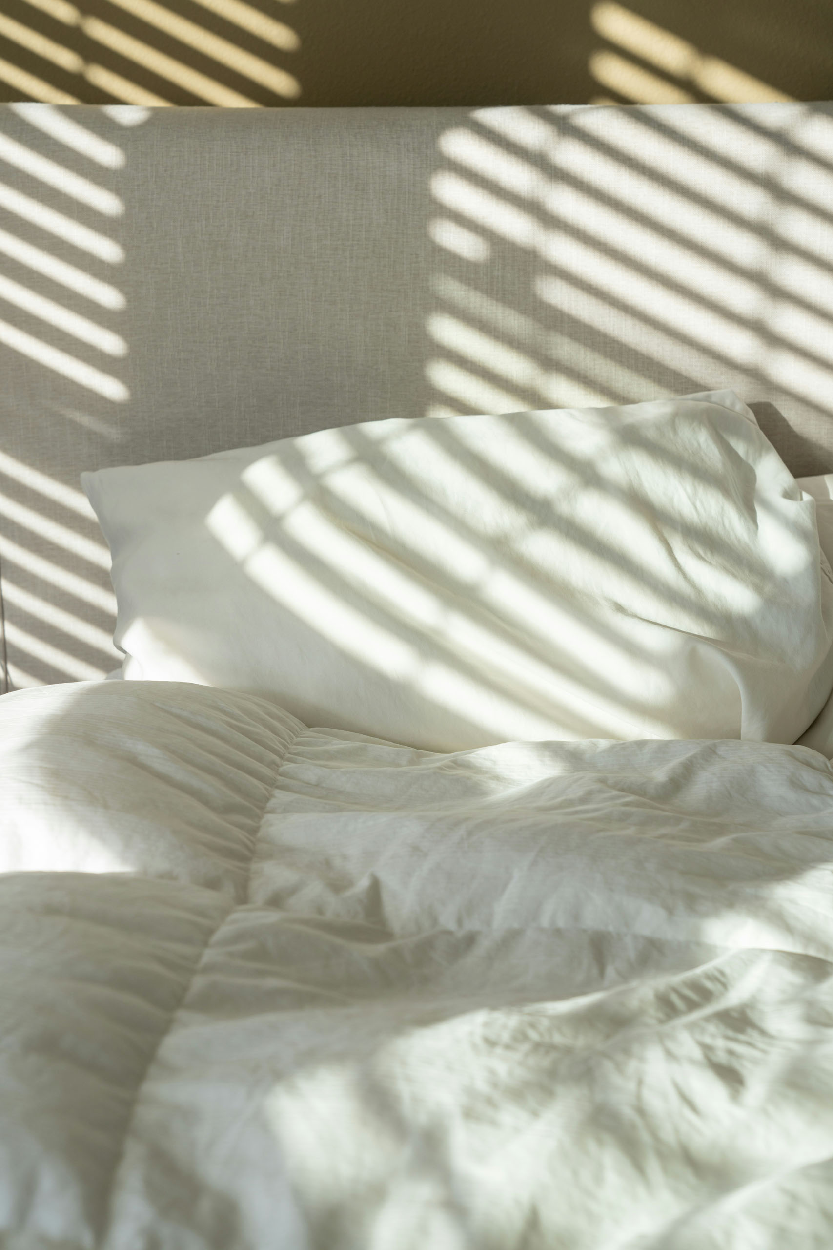 Shadow patterns across white sheets
